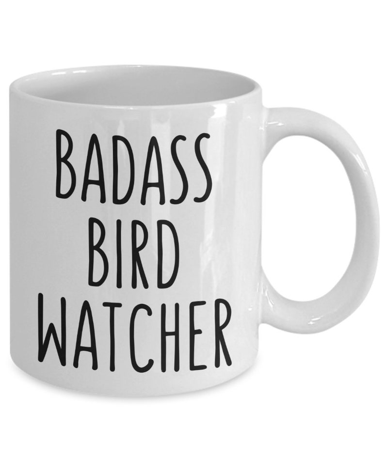 May include: White ceramic coffee mug with black text that reads "BADASS BIRD WATCHER".