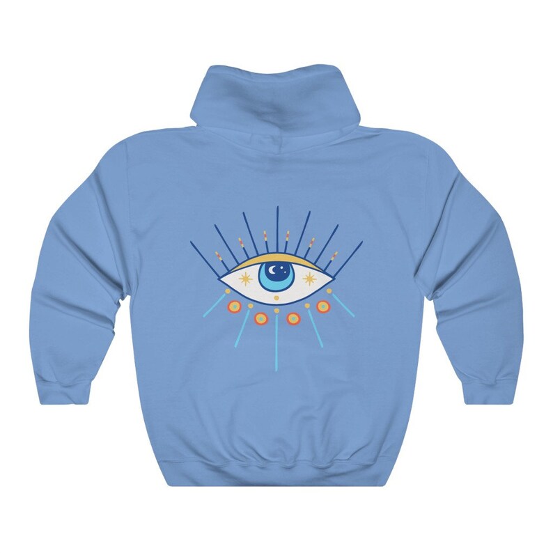 May include: A light blue hooded sweatshirt with a colorful evil eye design on the front. The eye is blue with a white pupil and surrounded by yellow stars and orange and blue rays.