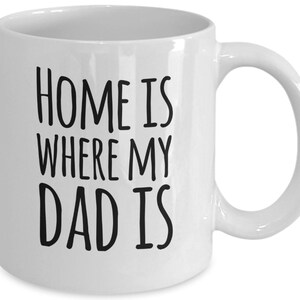 May include: White ceramic coffee mug with black text that reads "Home is where my dad is".