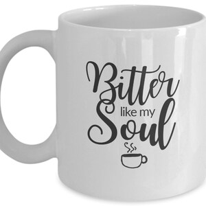 Op de afbeelding: Witte keramische koffiemok met zwarte tekst die "Bitter like my Soul" luidt en een kleine zwart-witte illustratie van een koffiekopje met stoom die eruit opstijgt.