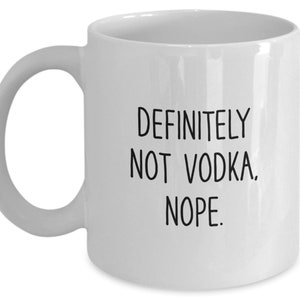 May include: White ceramic coffee mug with black text that reads "DEFINITELY NOT VODKA. NOPE."