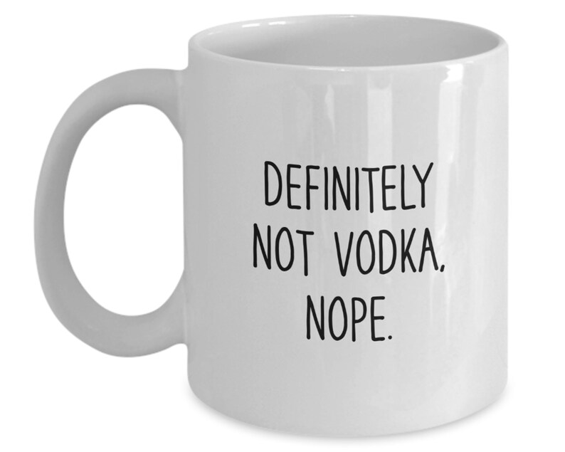 May include: White ceramic coffee mug with black text that reads "DEFINITELY NOT VODKA. NOPE."