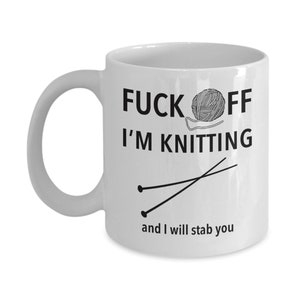 Puede incluir: Taza de caf&eacute; de cer&aacute;mica blanca con texto negro que dice "F*ck Off I'm Knitting" y un dibujo de agujas de tejer y lana.
