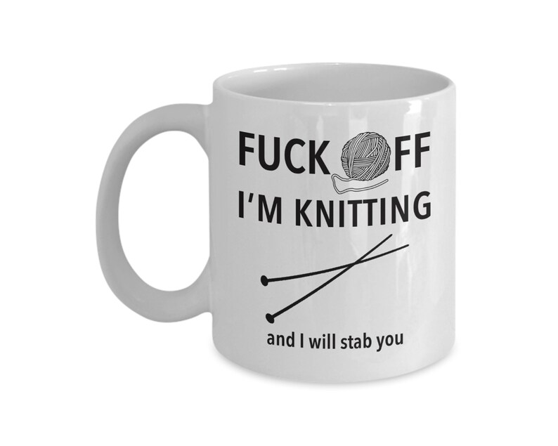 Puede incluir: Taza de caf&eacute; de cer&aacute;mica blanca con texto negro que dice "F*ck Off I'm Knitting" y un dibujo de agujas de tejer y lana.