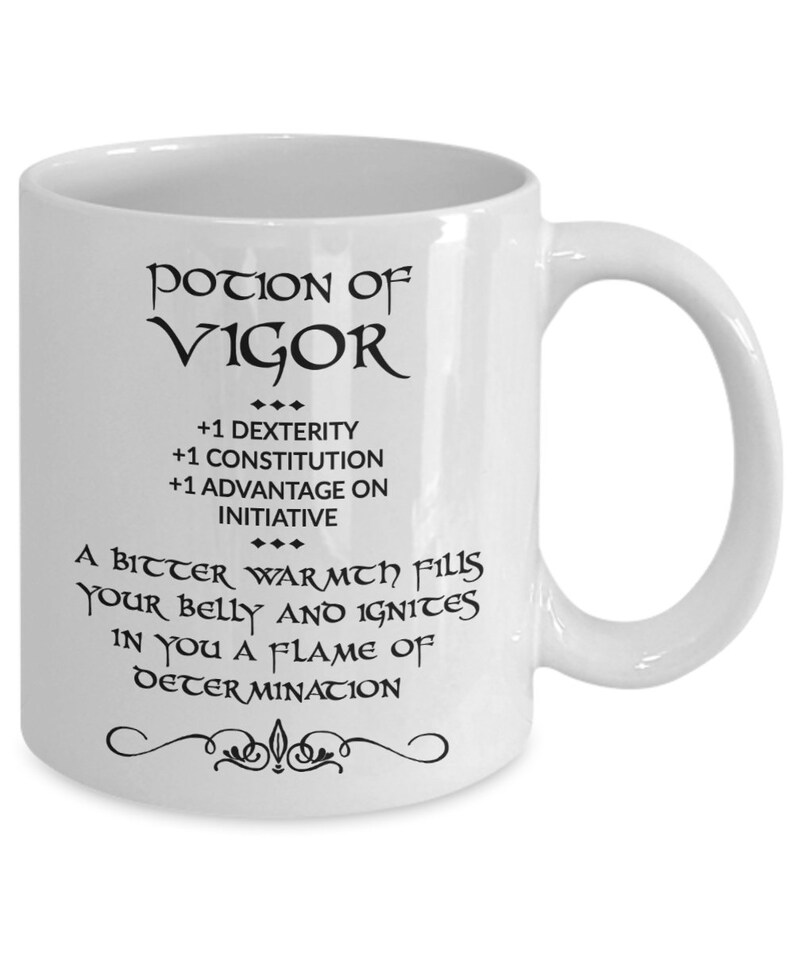 May include: White ceramic mug with the words "POTION OF VIGOR" in black script. The mug also features text that reads "+1 DEXTERITY, +1 CONSTITUTION, +1 ADVANTAGE ON INITIATIVE" and "A BITTER WARMTH FILLS YOUR BELLY AND IGNITES IN YOU A FLAME OF DETERMINATION."