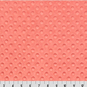 May include: Coral pink textured fabric with a repeating pattern of small raised circles.