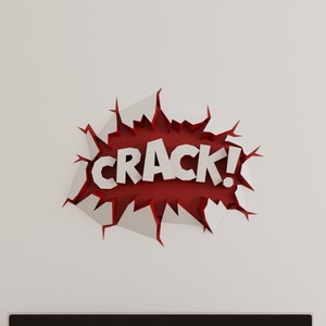 May include: A black flat screen television is mounted on a white wall above a light brown wooden entertainment unit. A red and white wall decal with the word "CRACK!" is above the television.