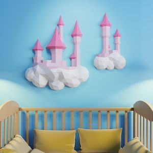Puede incluir: Un castillo de papel rosa y blanco con una base en forma de nube, colgado en una pared azul claro sobre una cuna de madera con almohadas amarillas.