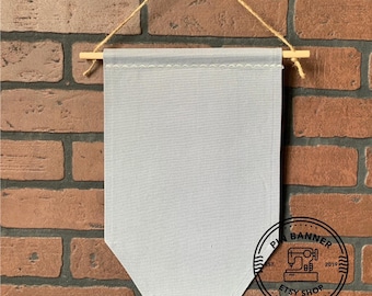 Grote canvas banner in grijs met trapeziumvormige bodem, inclusief pluggenstang en touwtje, lege grijze pinbanner, emaille collectiebanner