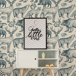 May include: A nursery room with a teepee tent, a white shelf with a sign that says "hello little one", and a blue and white wallpaper with animal illustrations.