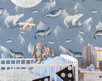 May include: A white crib with a blue and white patterned bumper pad and a white and black patterned bunting. The crib is in a room with a blue and white wallpaper featuring polar bears and seals on ice floes.
