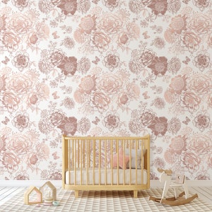 May include: A nursery room with a white wall covered in a floral wallpaper pattern in shades of pink and brown. A wooden cot with a pink pillow is in the foreground. A rocking horse is on the floor.