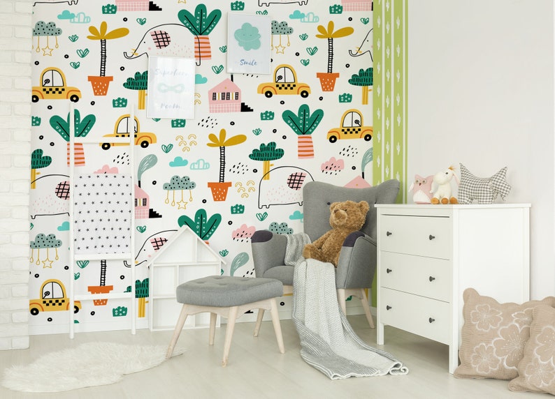Pu&ograve; includere: Una parete di una cameretta bianca con una carta da parati colorata che presenta un motivo ripetitivo di elefanti, palme, auto, case e nuvole. La carta da parati ha un design fantasioso e giocoso.