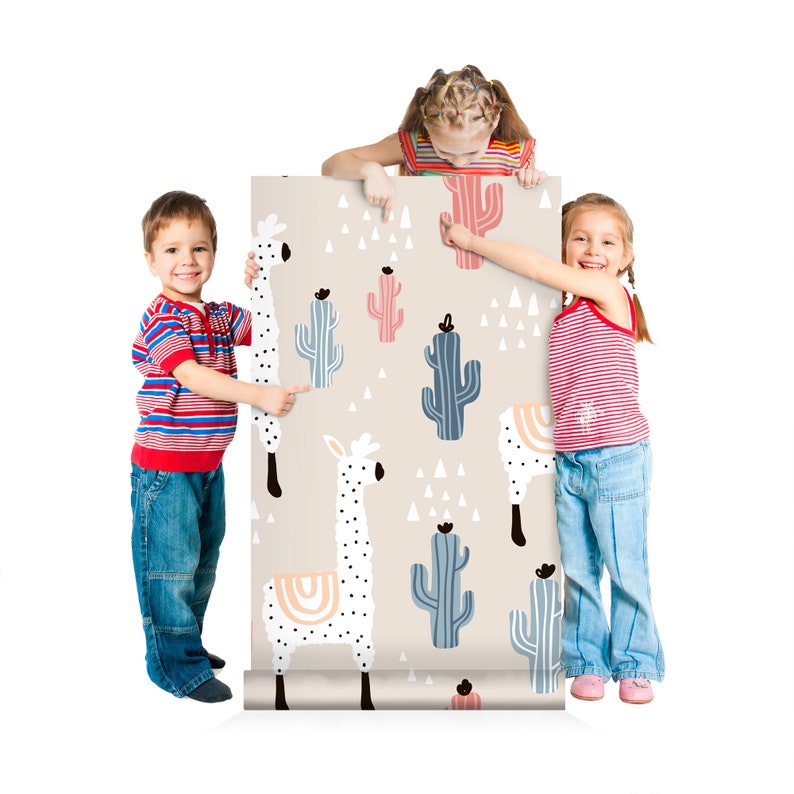 Puede incluir: Un rollo de papel pintado con un patr&oacute;n repetido de llamas blancas, cactus en tonos azules y rosas, y tri&aacute;ngulos blancos sobre un fondo beige. El papel pintado est&aacute; siendo sujetado por tres ni&ntilde;os.