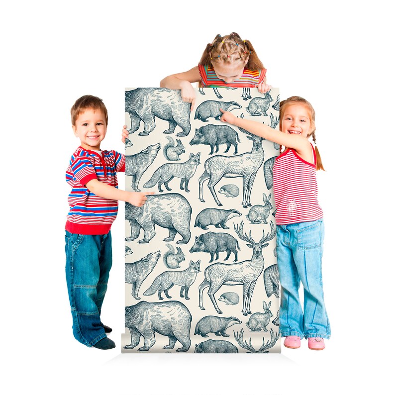 May include: Two children stand on either side of a roll of wallpaper featuring a repeating pattern of blue and white illustrations of forest animals, including bears, deer, foxes, and rabbits.