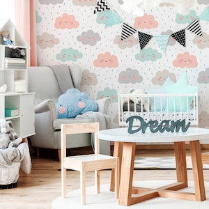 May include: A nursery room with a white crib, a gray armchair, a wooden table and chairs, and a white shelf with toys. The wall is decorated with a wallpaper featuring a pattern of clouds with smiling faces and raindrops.
