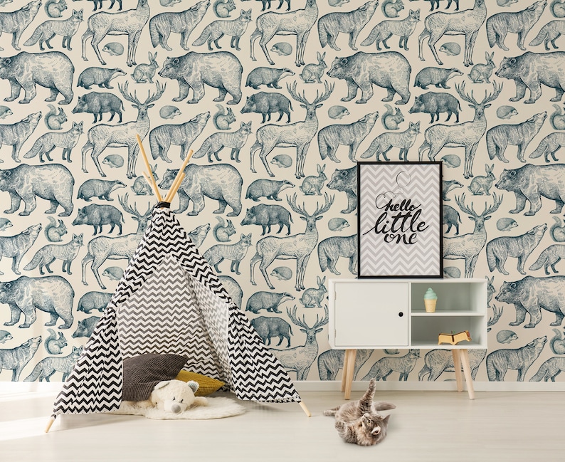 May include: A nursery room with a teepee tent, a white shelf with a sign that says "hello little one", and a blue and white wallpaper with animal illustrations.