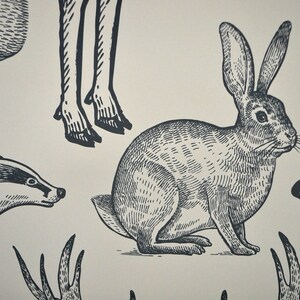 May include: Black and white line drawing illustration of a rabbit, badger, deer legs, and a bear head. The animals are drawn in a vintage style.