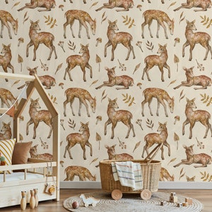 May include: A beige wallpaper with a repeating pattern of brown deer with white spots, brown leaves, and red berries. The wallpaper is in a room with a wooden crib and a wicker basket.