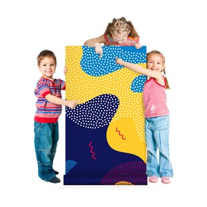 May include: Three children stand in front of a colorful, abstract patterned poster. The poster has blue, yellow, red, and white polka dots and wavy lines. The children are pointing at the poster.