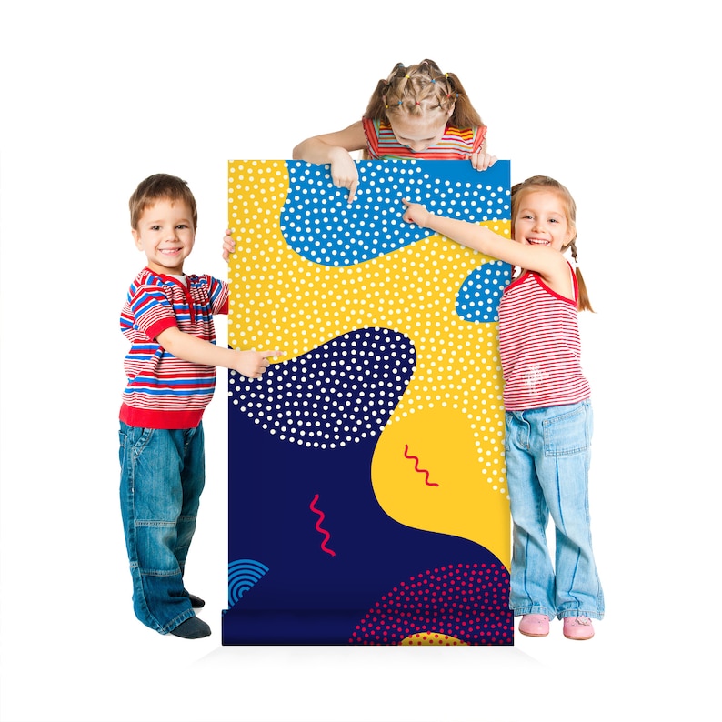 May include: Three children stand in front of a colorful, abstract patterned poster. The poster has blue, yellow, red, and white polka dots and wavy lines. The children are pointing at the poster.