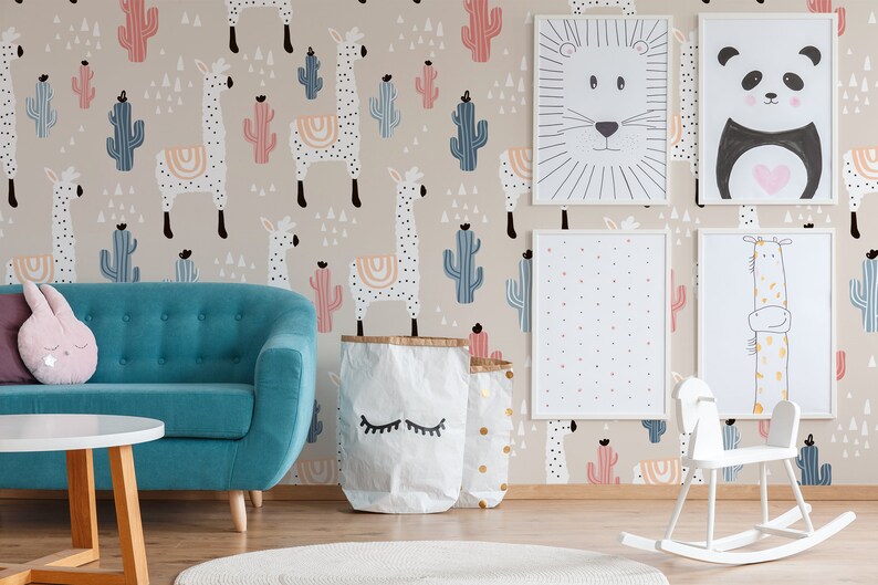 Puede incluir: Una habitaci&oacute;n infantil con un sof&aacute; turquesa, un balanc&iacute;n blanco y una mesa redonda blanca. Las paredes est&aacute;n decoradas con arte de animales enmarcados y un papel pintado beige con llamas y cactus en colores pastel. Dos bolsas de papel con ojos cerrados est&aacute;n en el suelo.