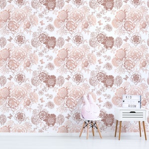 May include: A white wall with a floral wallpaper pattern in shades of pink and brown. The wallpaper features a repeating pattern of flowers and butterflies. A white bedside table with a wooden top and a white light box with the text "KID ROOM" is in the lower right corner of the image. A white chair with a pink bunny rabbit cushion is in the lower left corner of the image.