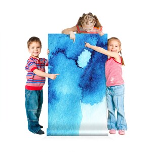 Puede incluir: Tres ni&ntilde;os se paran frente a una gran pintura de acuarela azul. Los ni&ntilde;os est&aacute;n se&ntilde;alando la pintura. La pintura tiene un fondo azul claro con vetas de acuarela azul oscuro.