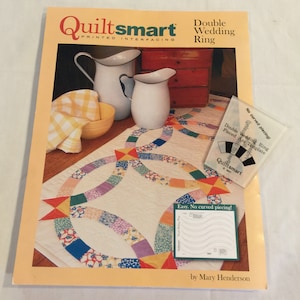 May include: Quiltsmart Double Wedding Ring quilt pattern book featuring a colourful quilt design on the cover. The book includes a template for piecing the quilt and instructions for making the quilt.