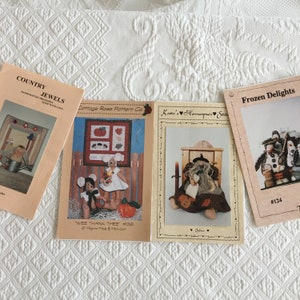 May include: Three different craft patterns for making dolls. The first pattern is for a group of mice, the second is for a witch doll, and the third is for a group of penguins. The patterns are titled "Wee Thank Thee #136", "Katie's Homespun Stitches", and "Frozen Delights #124".