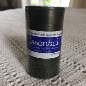 Puede incluir: Una bobina de hilo de satén de algodón egipcio 100% de color verde oscuro, etiquetada "Essential" de ConnectingThreads.com, con un tamaño de 50 y 1200 yardas.