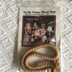 May include: A package of curly crepe wool hair for dolls. The package shows a variety of dolls with the hair. The text on the package reads "Curly Crepe Wool Hair, Beautiful, natural doll hair - 100% wool, Triples in length".