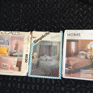 Puede incluir: Tres sobres de patrones de costura vintage con decoración de dormitorio. Los patrones incluyen diseños para cortinas, ropa de cama y otros elementos esenciales para el hogar. Los sobres están etiquetados como "McCall's" y "Simplicity".