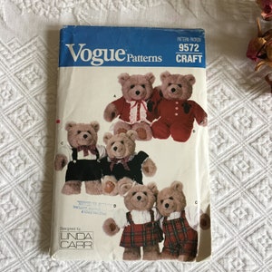 May include: A vintage Vogue Patterns sewing pattern for making teddy bears. The pattern is for Craft pattern number 9572 and is designed by Linda Carr. The pattern shows five different teddy bears wearing various outfits, including a red dress, a plaid skirt, and a black and white outfit.