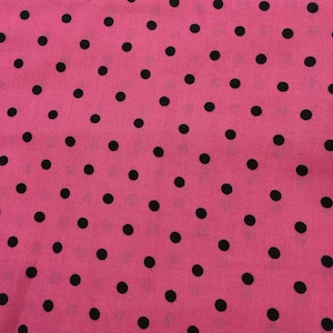 May include: A fabric textile featuring a vibrant hot pink background decorated with a repeating pattern of small, solid black polka dots evenly spaced across the entire surface, creating a consistent and uniform graphic design throughout the material.
