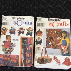 Può includere: Due buste di modelli di cucito Simplicity Crafts vintage. Uno presenta disegni di orsacchiotti, l'altro mostra una ragazza con un grembiule di orsacchiotto. Entrambi includono illustrazioni di vari progetti di animali di peluche.