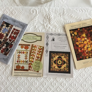 May include: Three quilting patterns featuring autumn themes. The patterns are titled "Nama's Pretties", "Cotton Way", and "Impressions of Autumn". The patterns feature fall colors like red, orange, and yellow.