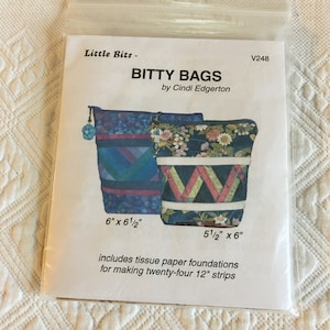 May include: A sewing pattern for two small bags called "Bitty Bags" by Cindi Edgerton. The pattern includes instructions for making twenty-four 12-inch strips using tissue paper foundations. The bags are 6 inches by 6 1/2 inches and 5 1/2 inches by 6 inches.