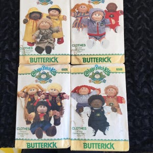 May include: Four vintage Butterick sewing patterns for Cabbage Patch Kids clothes. The patterns feature illustrations of the dolls in various outfits. The patterns are labelled with the Butterick logo and the words "CLOTHES For your Cabbage Patch Kids".