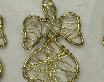 Op de afbeelding: Een goudkleurig draad engelenornament met een halo, vleugels en een rokachtige onderkant. De engel is versierd met kleine, heldere, iriserende kralen. De draad is ingewikkeld geweven om de vorm van de engel te creëren, geschikt voor vakantiedecoratie.