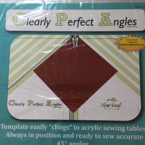 May include: A clear plastic template with a red square in the center. The template is designed to help sew accurate 45 degree angles. The text "Clearly Perfect Angles" is printed on the template.