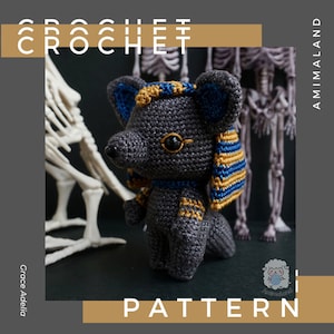 May include: Crochet pattern for a gray Anubis amigurumi with gold and blue details. The pattern is called "Animaland Crochet".