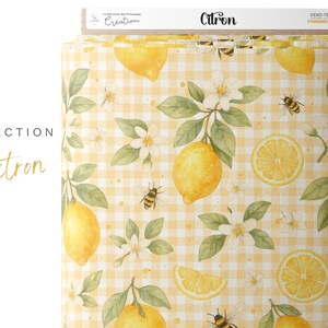 May include: A yellow and white gingham fabric with a lemon and bee pattern. The fabric has a white background with yellow squares and a pattern of lemons, bees, and white flowers. The fabric is labeled "Citron" and "Oeko-Tex Standard 100".