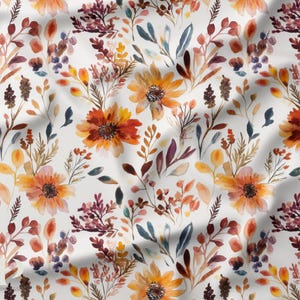 Peut inclure: Tissu à motif floral à l'aquarelle. Le motif présente des tournesols orange et jaunes, avec des accents de feuillage bordeaux, bleu et vert. Le motif est posé sur un fond blanc, créant un textile vibrant et artistique.