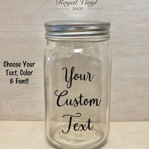 May include: A clear glass jar with a silver lid. The jar has a black vinyl sticker that says "Your Custom Text".