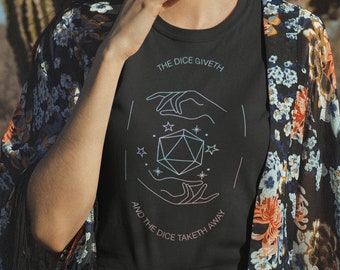May include: A black t-shirt with a graphic of a dice with hands on either side. The text on the shirt reads "The dice giveth and the dice taketh away".