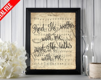 May include: A framed print displaying sheet music with the words "In the Garden" and the lyrics "And He walks with me and He talks with me" in a black frame. The print has a vintage aesthetic.