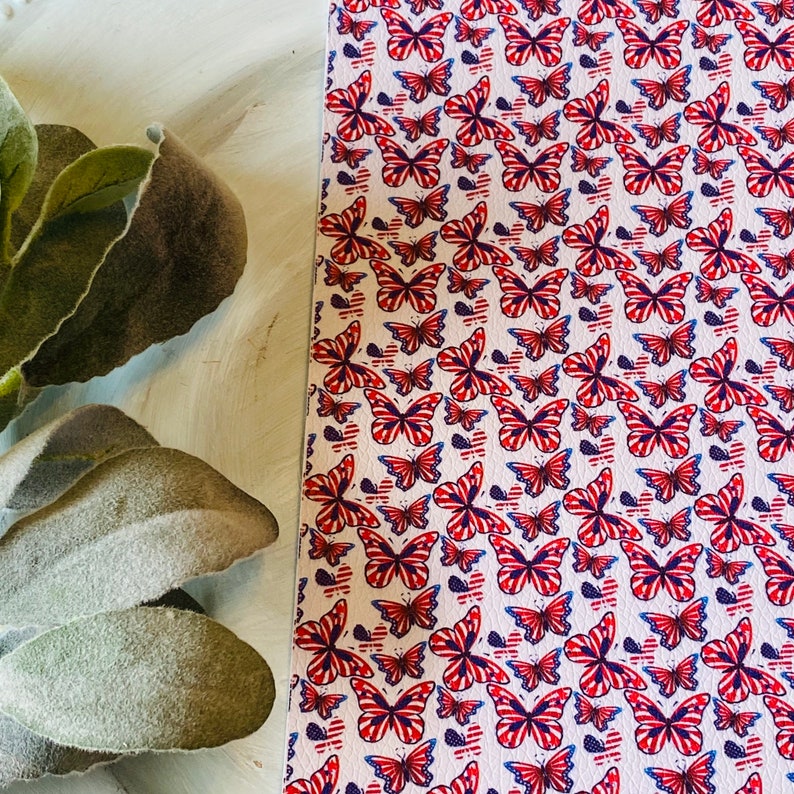 May include: White background with a repeating pattern of red, white, and blue butterflies. The butterflies have a patriotic design, with stripes and stars. The pattern is on a textured surface.