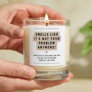 May include: A white soy wax candle with a brown label that reads "Smells like it's not your problem anymore!"  The label also includes the text "Good luck in your new job Sam. You will be so missed! From all the team."