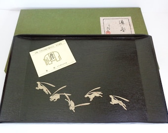 May include: A black lacquered tray with a design of five white rabbits running. The tray is in a green box with a label that says "道楽".